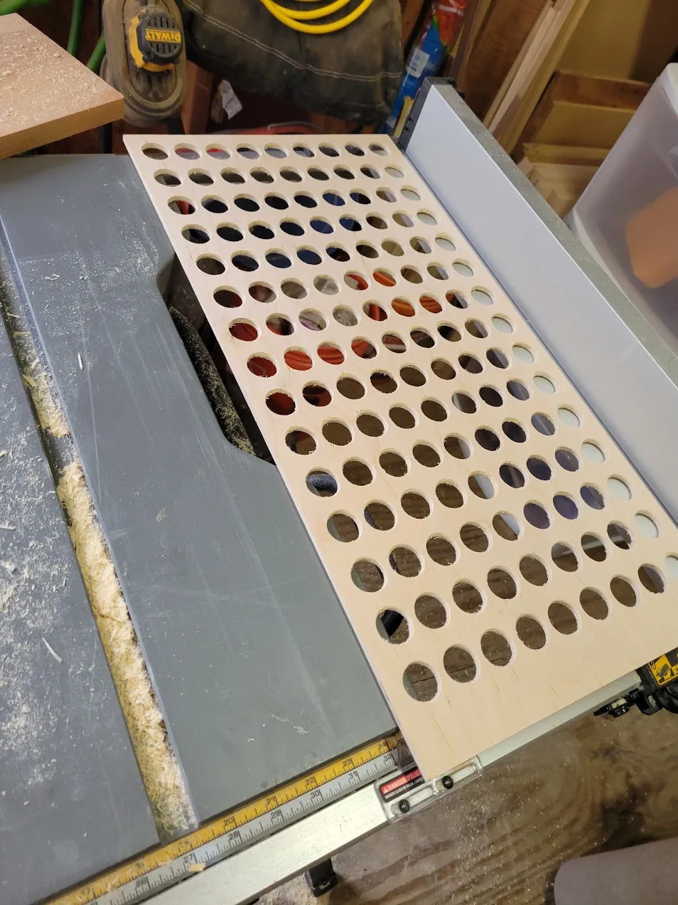 Baltic birch panel with a full grid of drilled holes for paint bottles