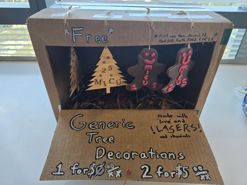 Cardboard gift-shop display box with laser-cut wood trees and epoxy gingerbread ornaments made for MICU staff