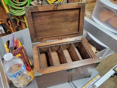 Open mahogany jewelry box with the box-jointed tray still seated inside