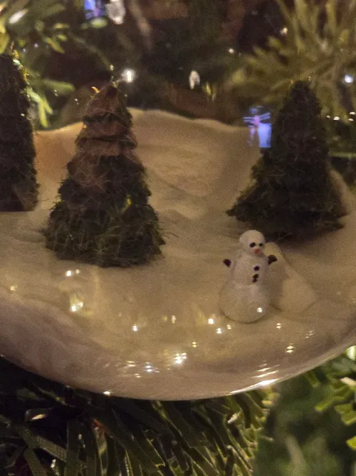 Close-up of the 3D-printed trees and clay snowman inside the globe